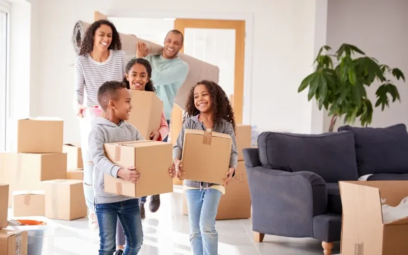 Family moving boxes into a new home with Renzo relocation accommodation